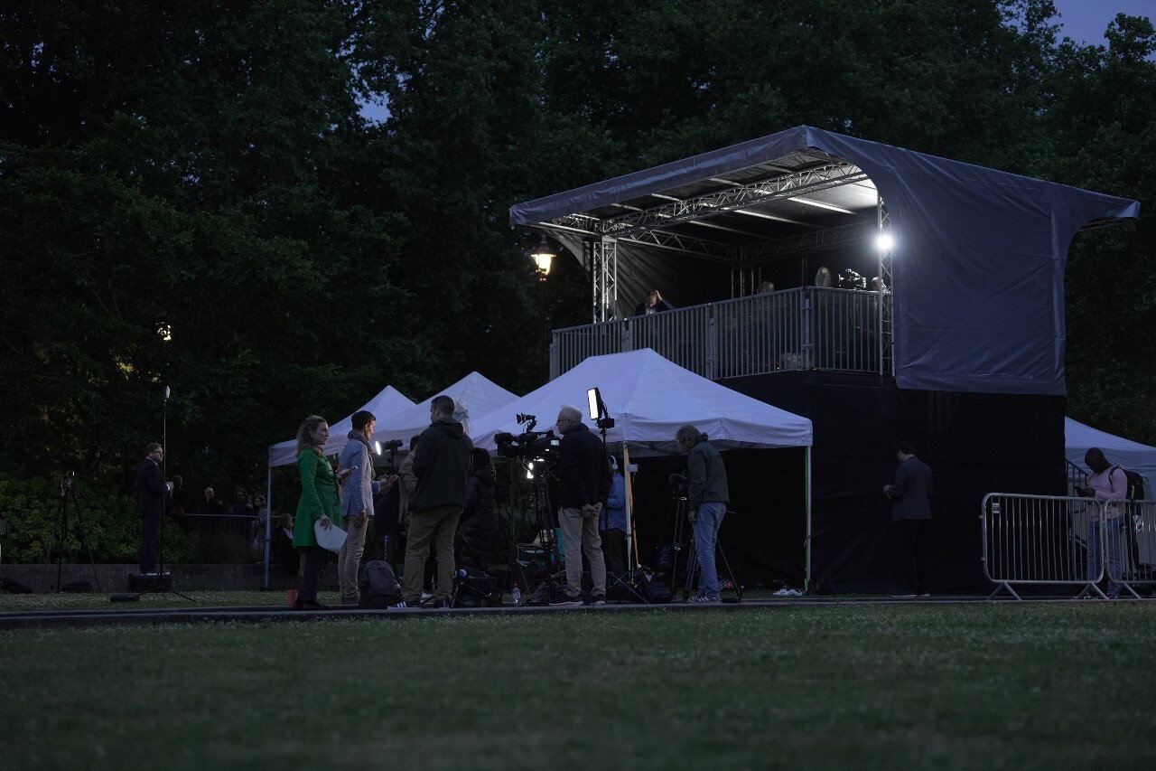 A large temporary building seen from a distance with several people in it.