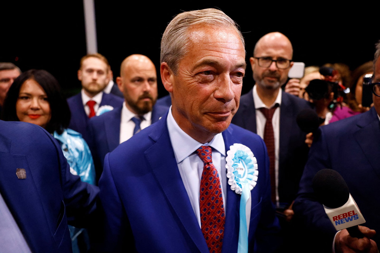 Man smiles wearing campaign badge 