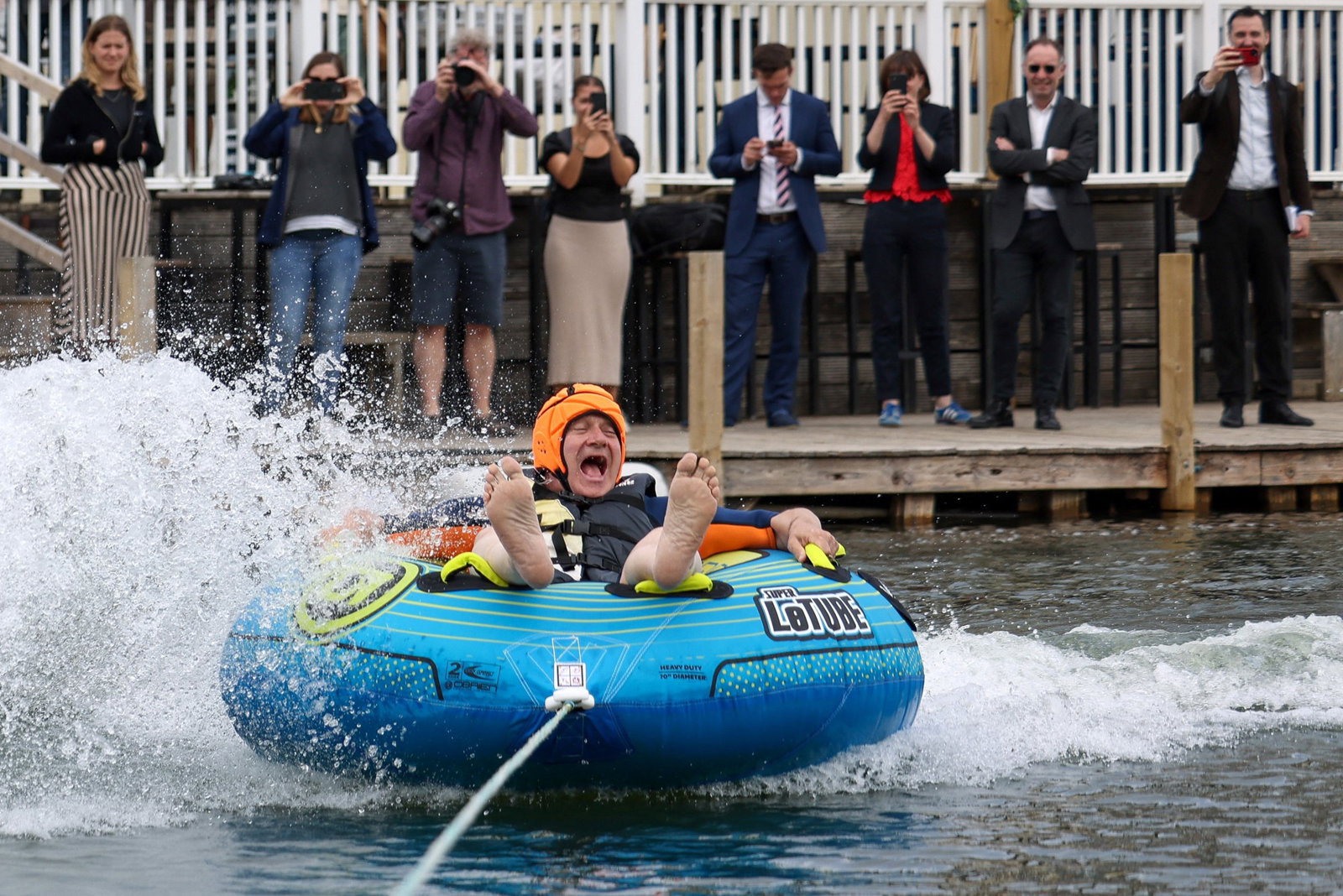 Man on inflatable tied to boat 